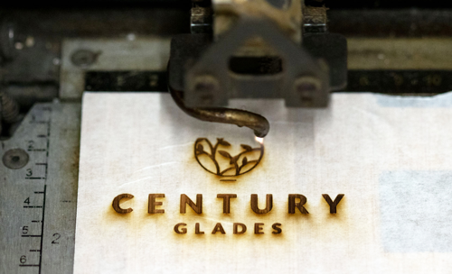 Laser engraving machine customising wooden promotional items with corporate branding